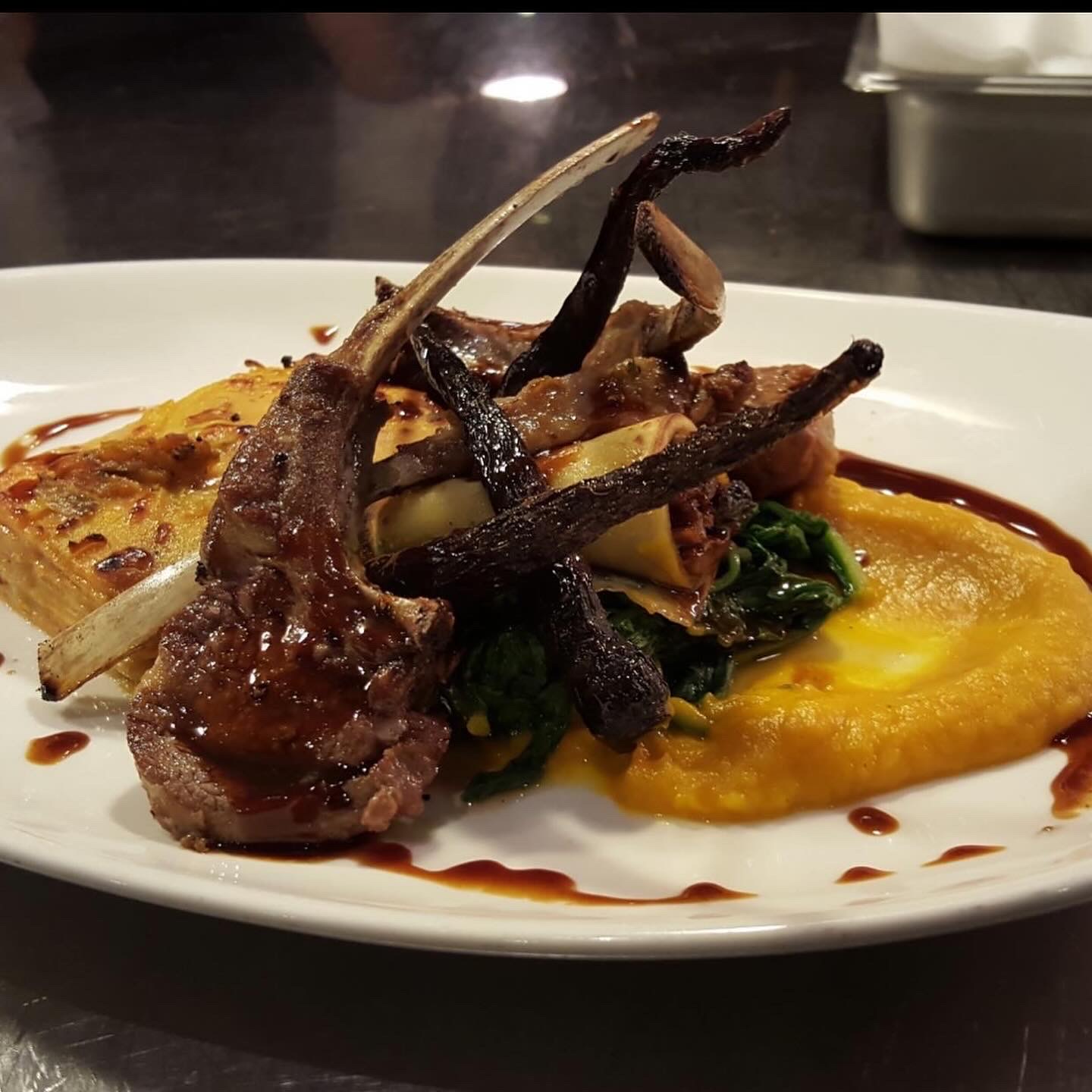 Plated lamb chops with kabocha purée and wild greens